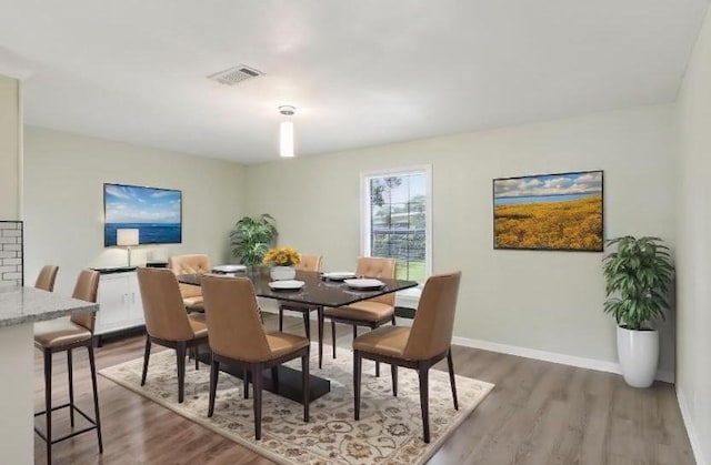 dining space with wood-type flooring