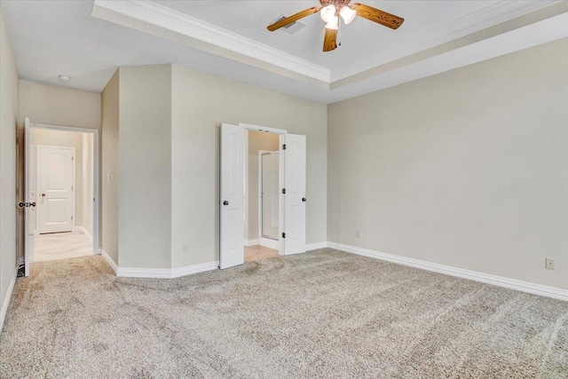 unfurnished bedroom with ceiling fan, a raised ceiling, crown molding, and light carpet