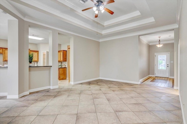 interior space with a tray ceiling, ceiling fan, light tile patterned floors, and ornamental molding