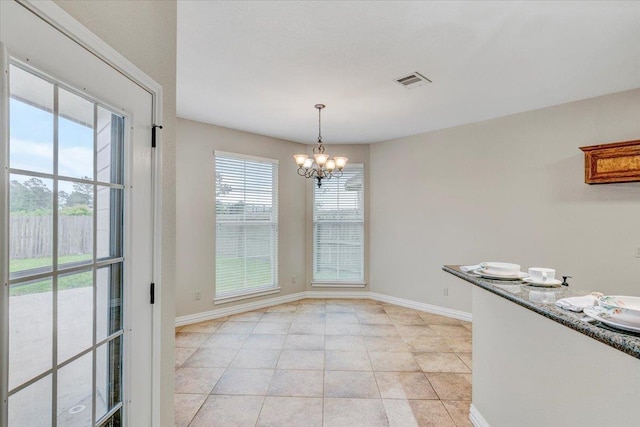 unfurnished dining area featuring light tile patterned floors and an inviting chandelier