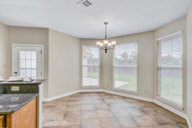 unfurnished dining area featuring a notable chandelier