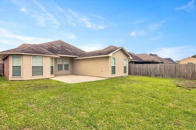 rear view of house featuring a yard and a patio