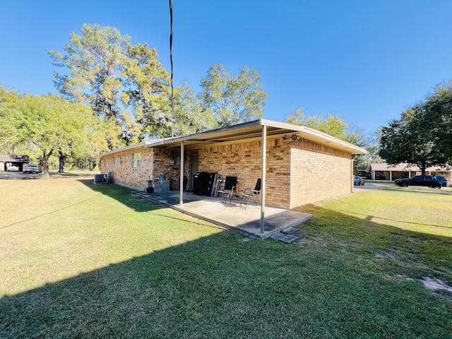 rear view of property featuring a lawn, central air condition unit, and a patio