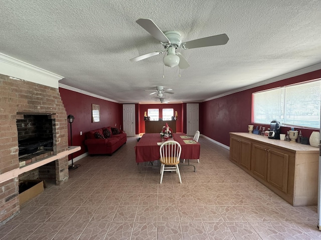 dining area with a textured ceiling, ceiling fan, crown molding, and a brick fireplace