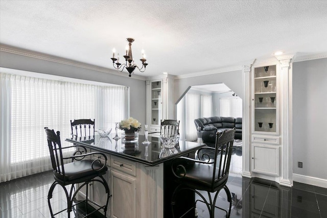 kitchen featuring a kitchen breakfast bar, crown molding, a textured ceiling, and a chandelier