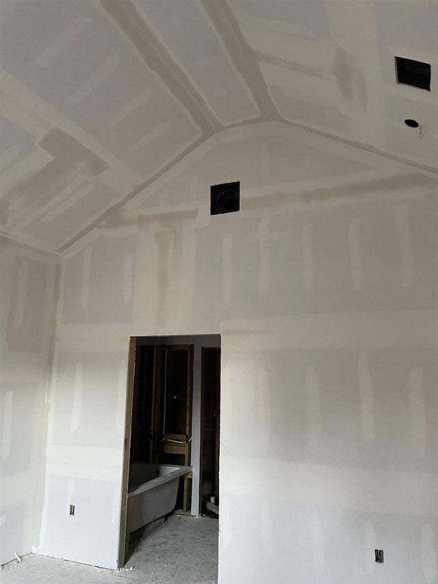 unfurnished room with lofted ceiling