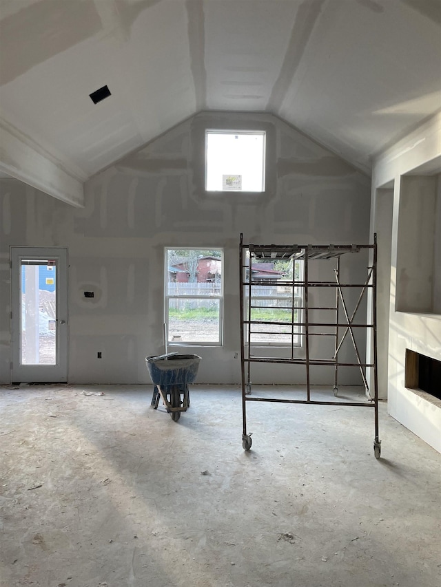 unfurnished living room with high vaulted ceiling