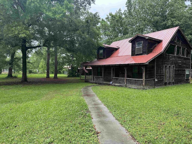 view of front of house featuring a porch, a front yard, and metal roof