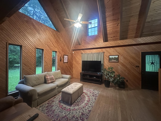 living area with high vaulted ceiling, ceiling fan, wood-type flooring, wood walls, and beam ceiling