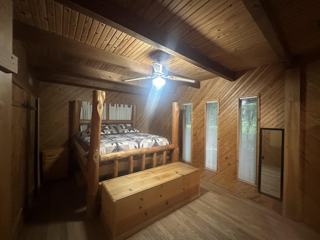 bedroom with wooden walls, wood finished floors, a ceiling fan, wooden ceiling, and beamed ceiling