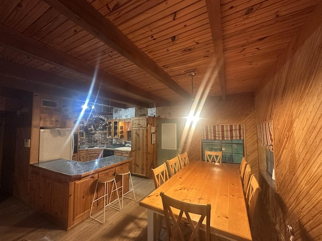 dining room featuring wooden ceiling, wood walls, wood finished floors, and visible vents