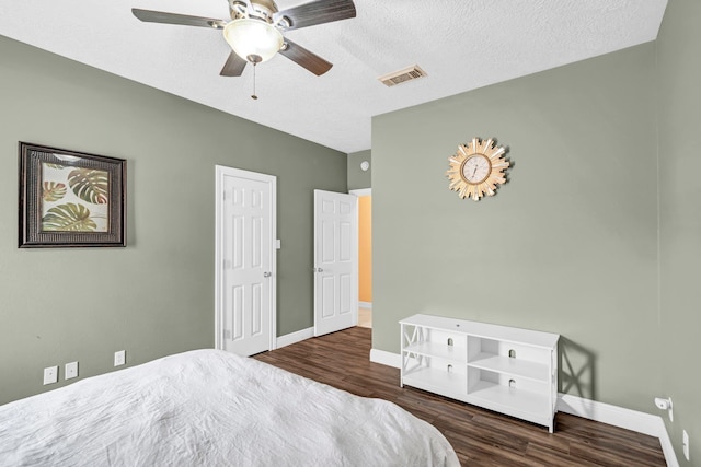 bedroom with a textured ceiling, dark hardwood / wood-style flooring, and ceiling fan