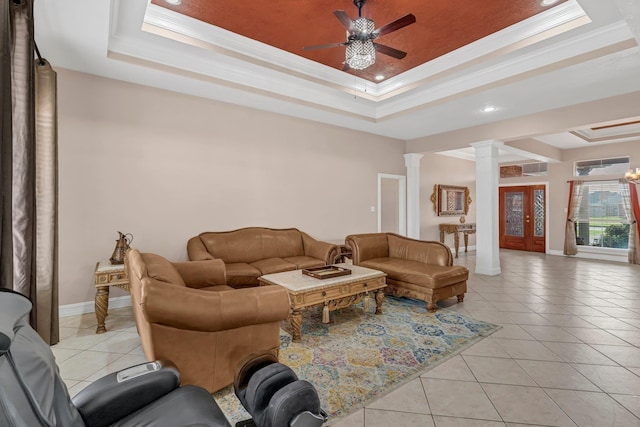 living room featuring a tray ceiling, decorative columns, and ornamental molding