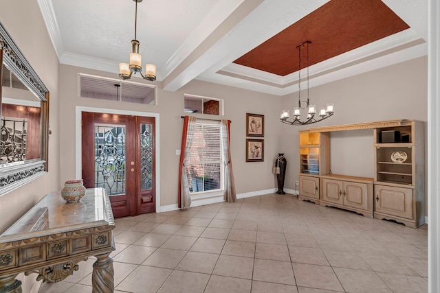 tiled entrance foyer featuring a tray ceiling, crown molding, and a notable chandelier