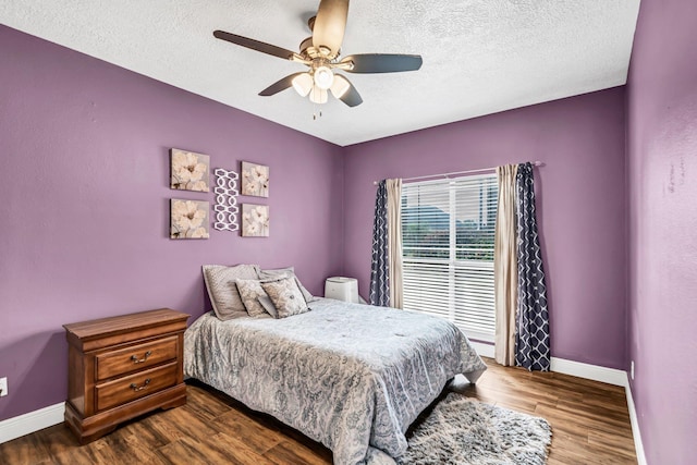 bedroom with ceiling fan, wood-type flooring, and a textured ceiling