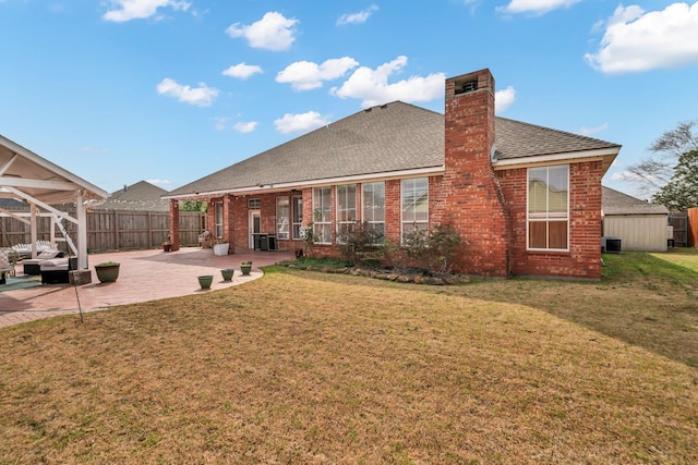 rear view of house with a patio area, a yard, and central AC unit