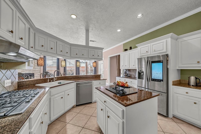 kitchen with white cabinetry, stainless steel appliances, light tile patterned floors, a kitchen island, and ornamental molding