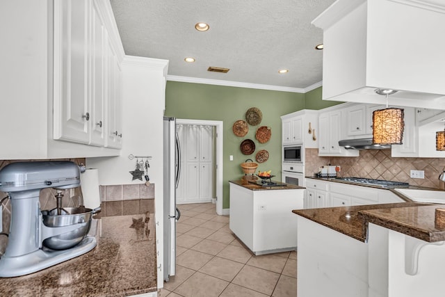 kitchen featuring kitchen peninsula, stainless steel appliances, extractor fan, white cabinets, and light tile patterned flooring