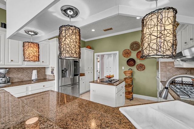 kitchen with decorative backsplash, ornamental molding, sink, stainless steel fridge with ice dispenser, and white cabinetry