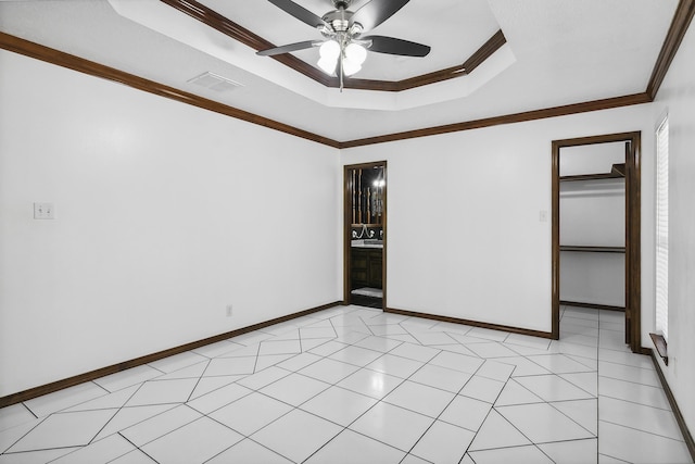 unfurnished room featuring a raised ceiling, crown molding, and ceiling fan