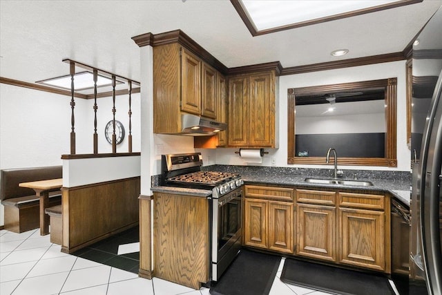 kitchen with appliances with stainless steel finishes, wooden walls, crown molding, sink, and light tile patterned floors