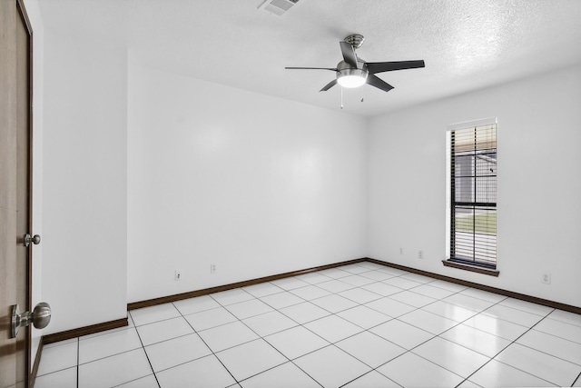 tiled empty room featuring ceiling fan and a textured ceiling