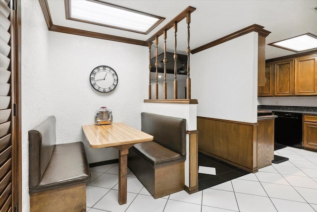 dining space with wood walls, light tile patterned floors, and crown molding