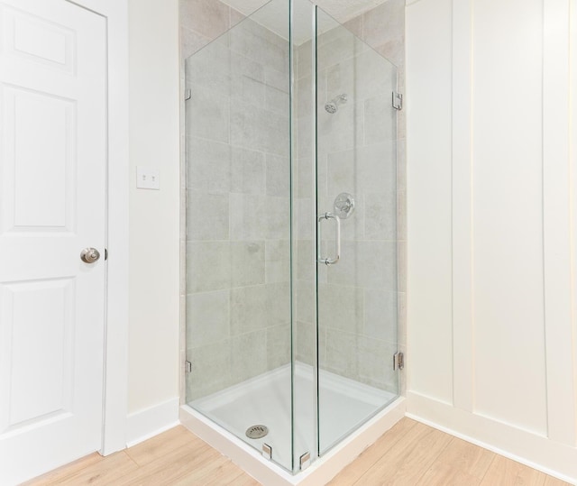 bathroom featuring hardwood / wood-style flooring and walk in shower