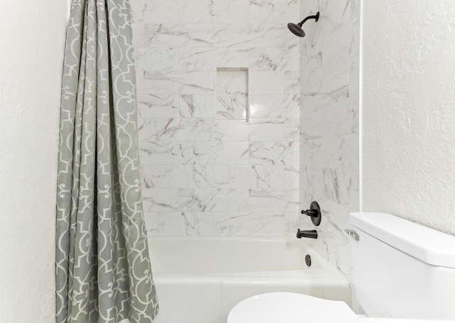 bathroom featuring shower / bath combo with shower curtain and toilet