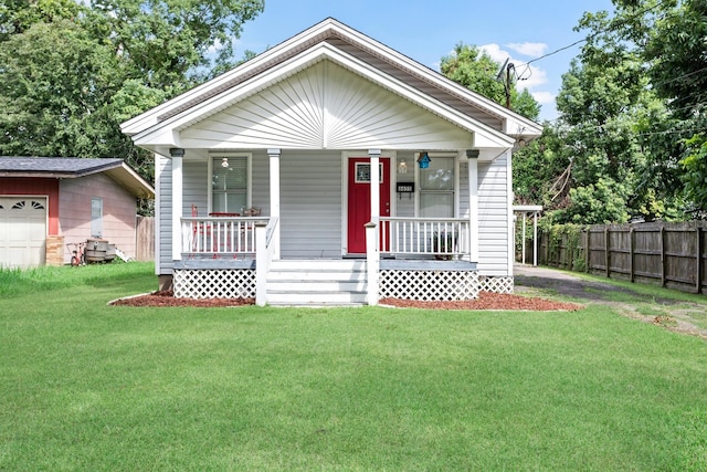 bungalow-style house with a front yard, a porch, a garage, and an outdoor structure