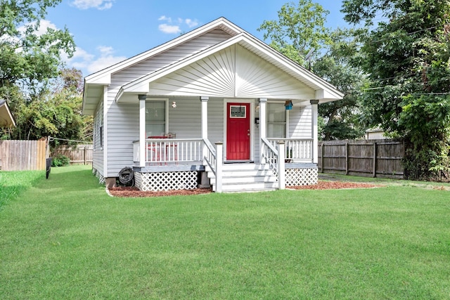 bungalow with covered porch and a front lawn