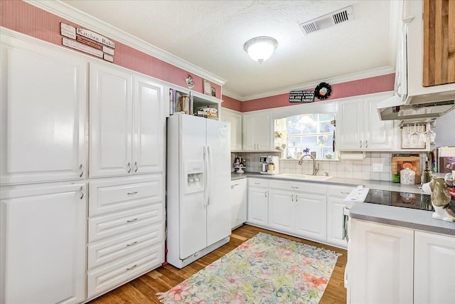 3821 Suncrest Dr, Groves, TX 77619 - kitchen with white appliances, light wood-type flooring, white cabinets, ornamental molding, and backsplash