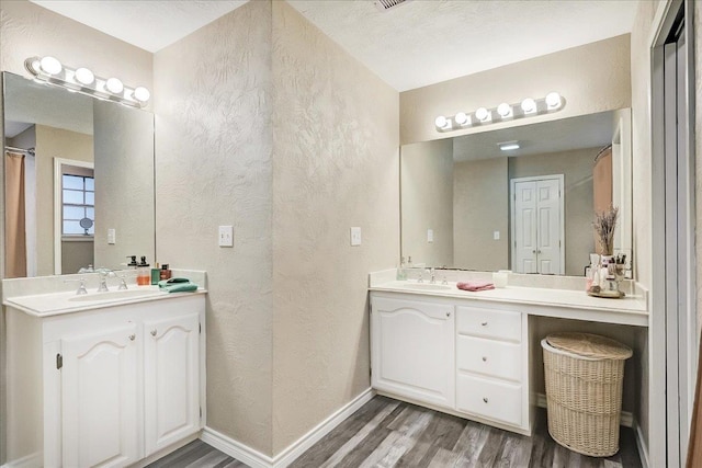 3821 Suncrest Dr, Groves, TX 77619 - bathroom featuring a textured wall, wood finished floors, and vanity