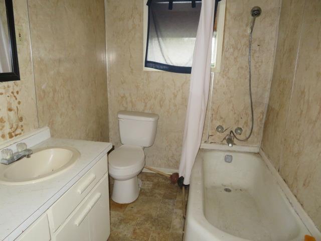 full bathroom with vanity, toilet, and shower / bath combo with shower curtain