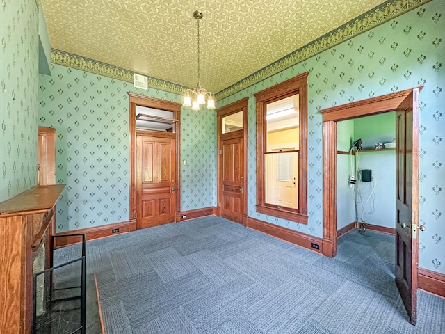 unfurnished bedroom featuring carpet flooring and a notable chandelier