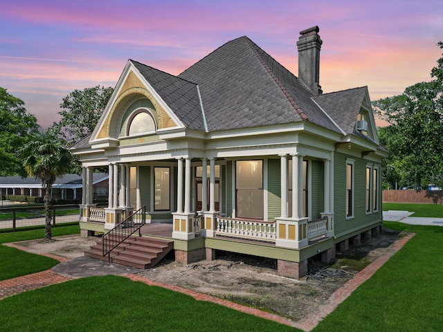 view of front of house featuring a lawn and covered porch