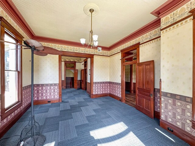 unfurnished room featuring ornamental molding and a notable chandelier