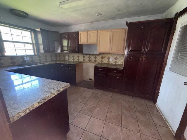 290 Rosine St, Beaumont, TX 77707 - kitchen featuring backsplash, light stone countertops, and light tile patterned floors