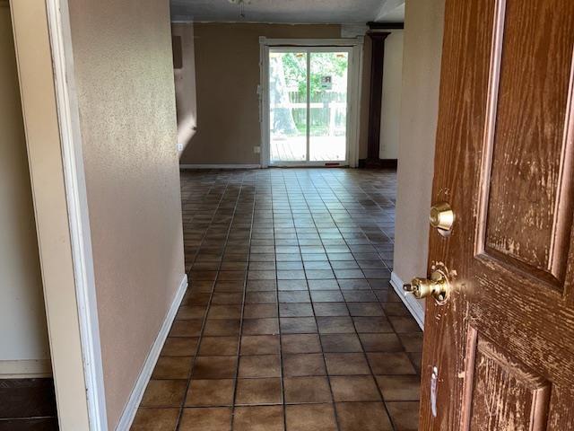 290 Rosine St, Beaumont, TX 77707 - corridor featuring baseboards and dark tile patterned flooring