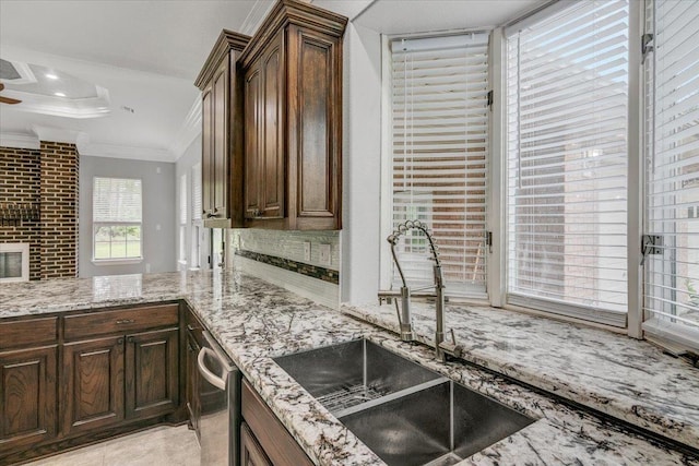 kitchen featuring dishwasher, crown molding, light stone countertops, and sink