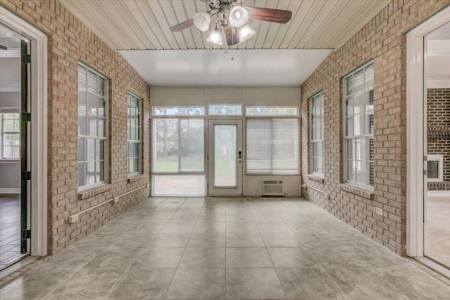 unfurnished sunroom with ceiling fan