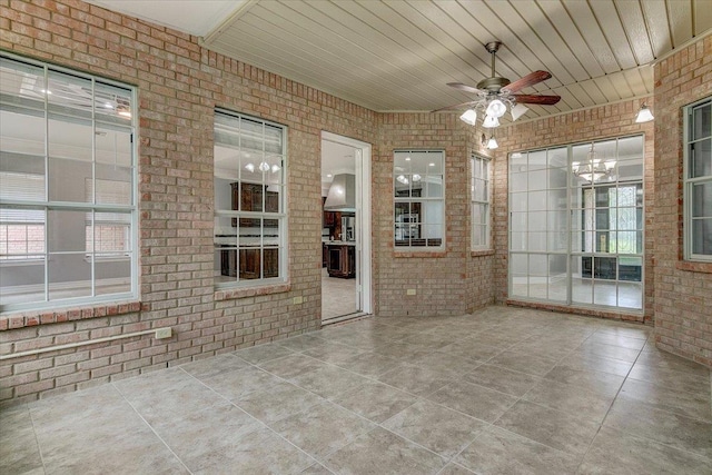 interior space with ceiling fan with notable chandelier and wood ceiling