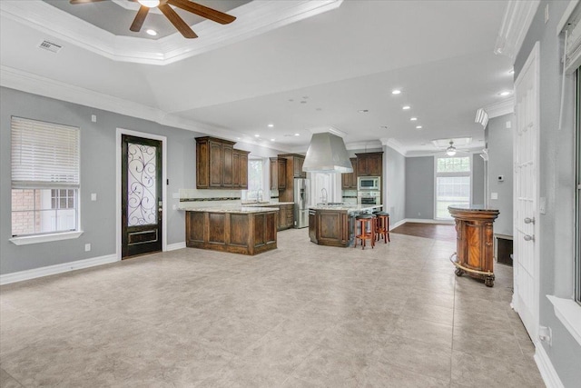 kitchen featuring a kitchen bar, a kitchen island, ornamental molding, and appliances with stainless steel finishes