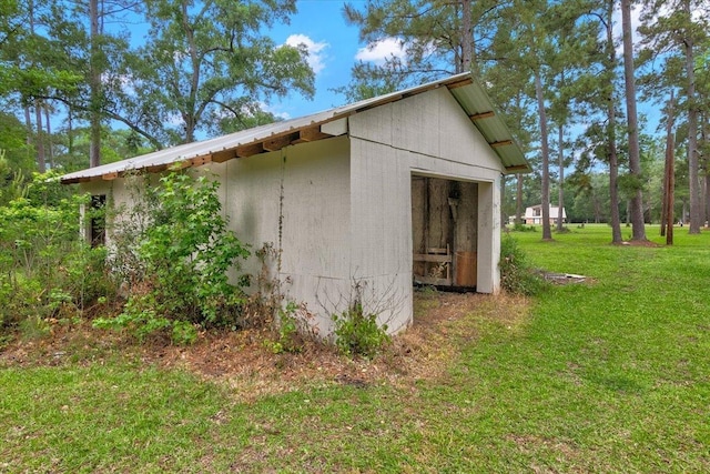 view of side of home with a lawn and a shed