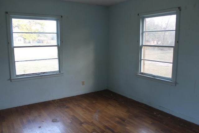 empty room with plenty of natural light and dark wood-style flooring