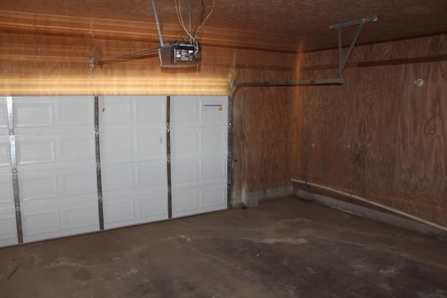 garage featuring wood walls and a garage door opener