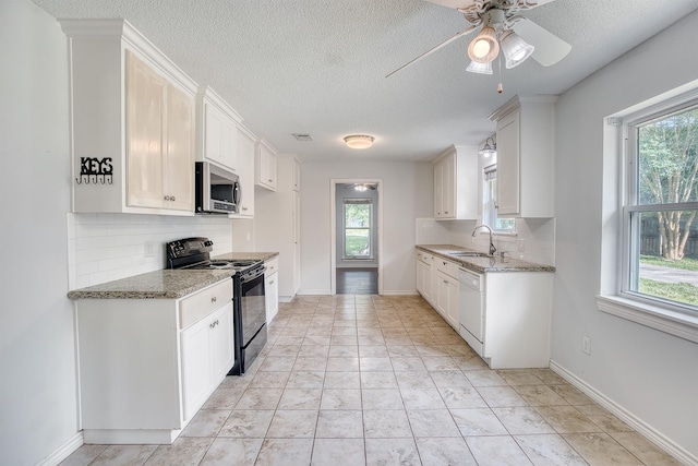 246 Pinevale Way, Sour Lake, TX 77659 - kitchen featuring black electric range, stainless steel microwave, dishwasher, decorative backsplash, and a textured ceiling