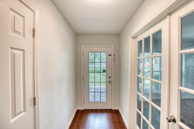 246 Pinevale Way, Sour Lake, TX 77659 - doorway to outside featuring dark wood finished floors, a textured ceiling, and baseboards