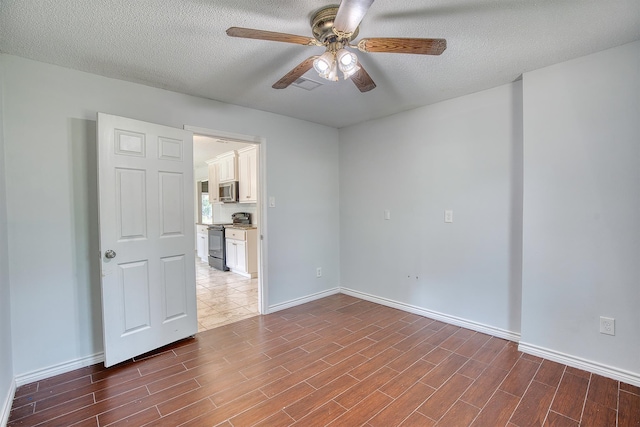 246 Pinevale Way, Sour Lake, TX 77659 - empty room featuring a ceiling fan, wood finished floors, baseboards, and a textured ceiling