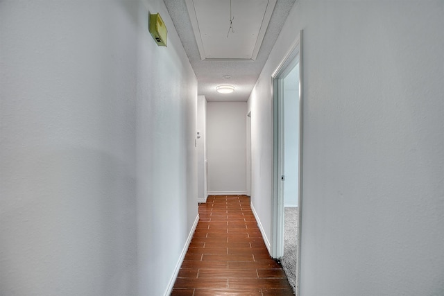 246 Pinevale Way, Sour Lake, TX 77659 - hallway featuring attic access, dark wood-style floors, baseboards, and a textured ceiling